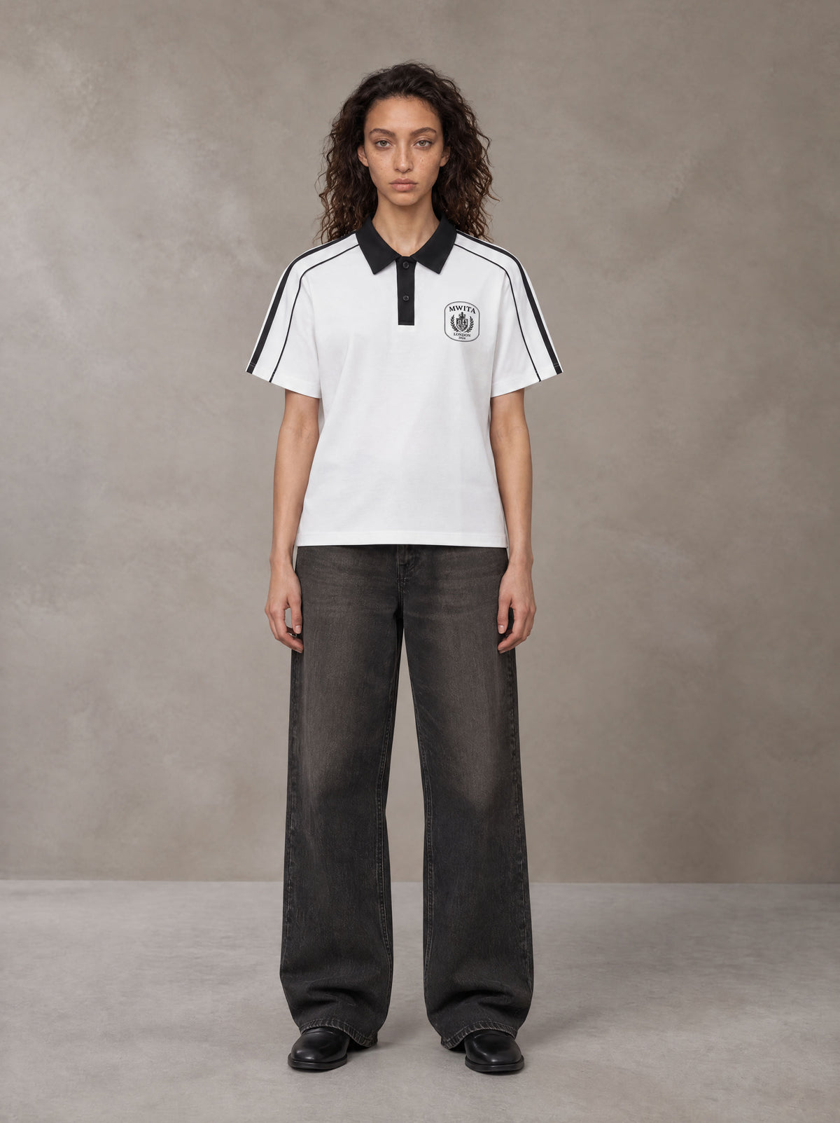 Model wearing the SM Royal Emblem Polo T-shirt in Lucent White, front view.
