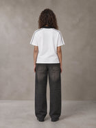 Model wearing the SM Royal Emblem Polo T-shirt in Lucent White, rear view.