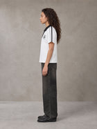 Model wearing the SM Royal Emblem Polo T-shirt in Lucent White, side profile.