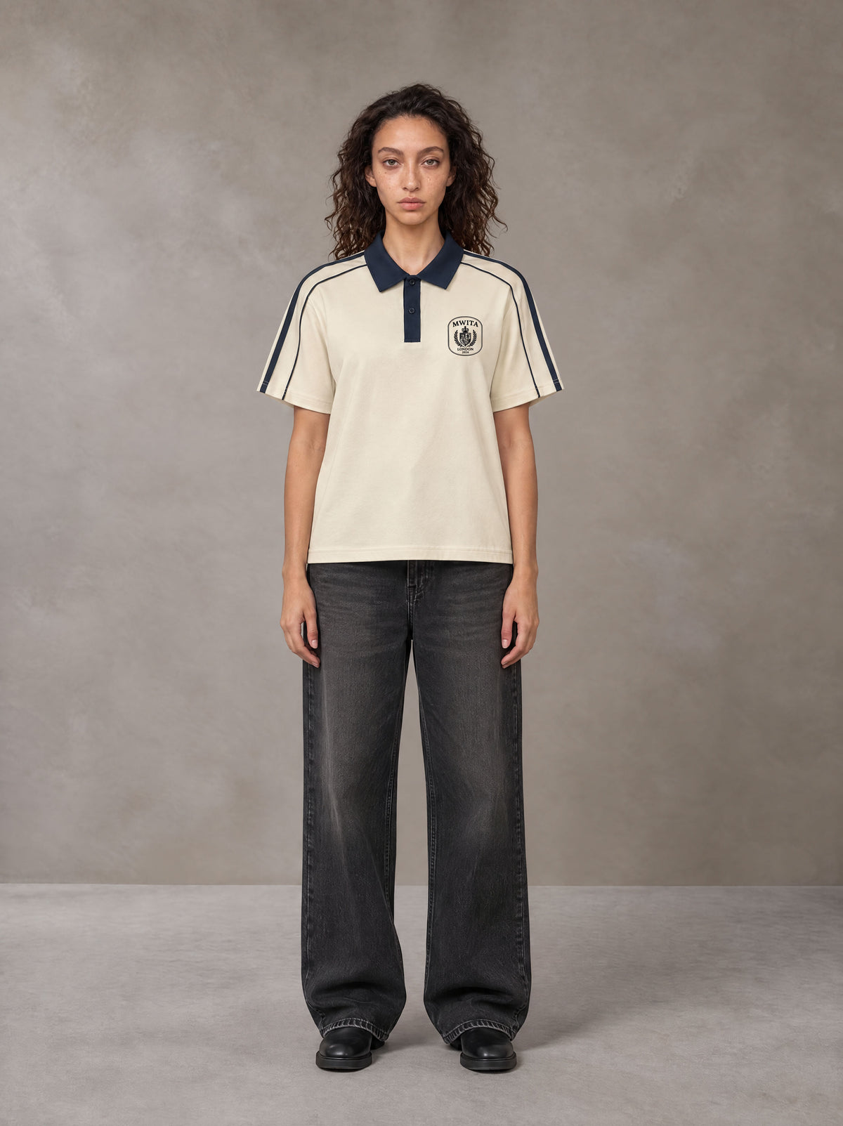 Model wearing the SM Royal Emblem Polo T-shirt in Soft Beige, front view.