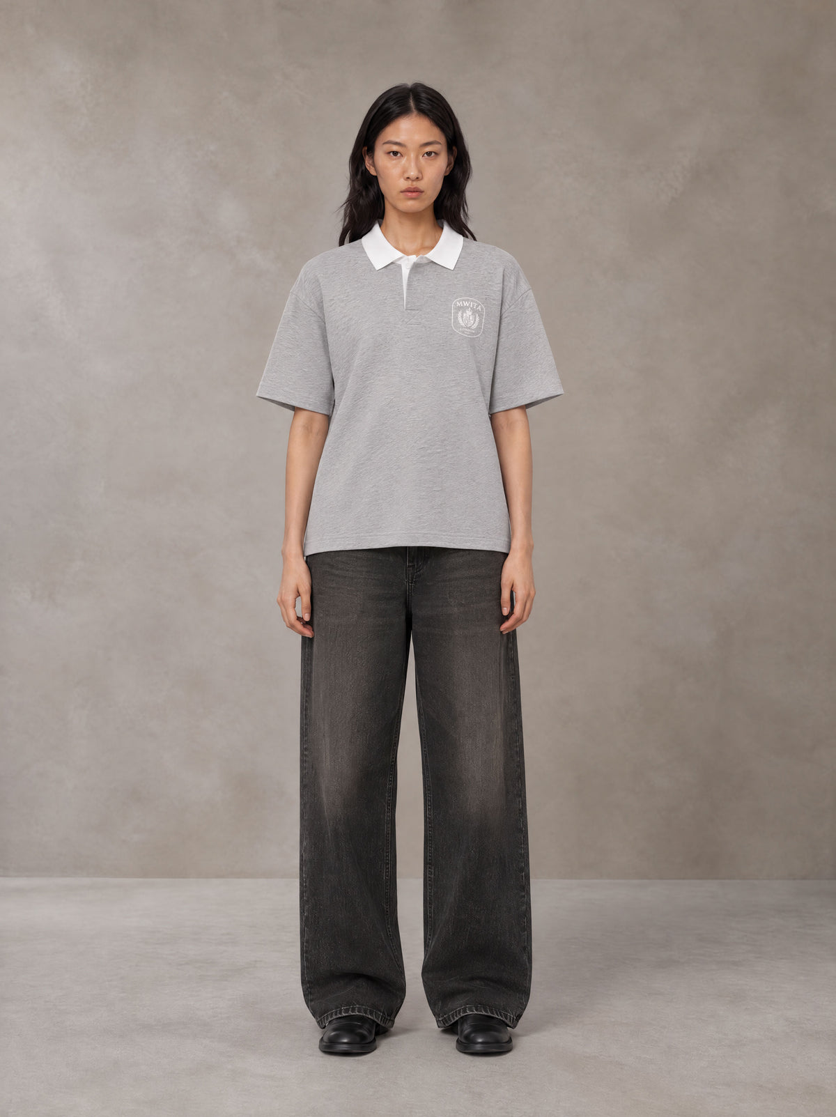 Model wearing the SM Royal Emblem Polo T-shirt in Floral Grey, front view.