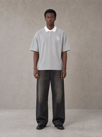 Model wearing the SM Royal Emblem Polo T-shirt in Floral Grey, front view.