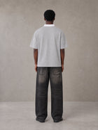 Model wearing the SM Royal Emblem Polo T-shirt in Floral Grey, rear view.