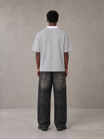 Model wearing the SM Royal Emblem Polo T-shirt in Floral Grey, rear view.