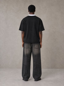 Model wearing the SM Royal Emblem Polo T-shirt in Midnight Black, rear view.