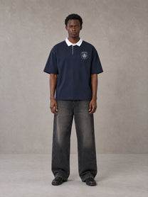 Model wearing the SM Royal Emblem Polo T-shirt in Oxford Navy, front view.