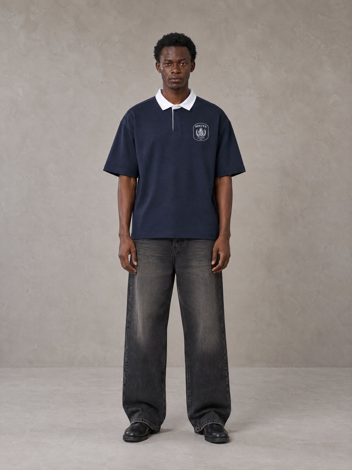 Model wearing the SM Royal Emblem Polo T-shirt in Oxford Navy, front view.