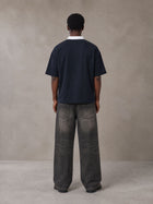 Model wearing the SM Royal Emblem Polo T-shirt in Oxford Navy, rear view.