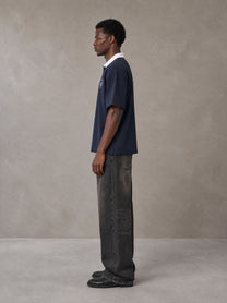 Model wearing the SM Royal Emblem Polo T-shirt in Oxford Navy, side profile.