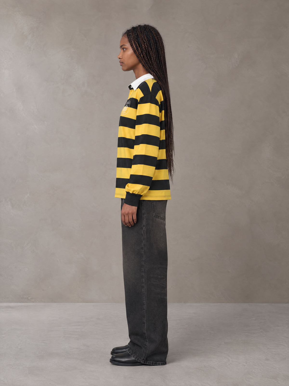 Model wearing the SM Royal Emblem Rugby Polo T-shirt in Arylide Yellow, side profile.