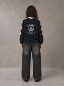 Model wearing the SM Royal Emblem Sport Sweatshirt in Midnight Black, rear view.