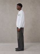 Model wearing the SM Royal Emblem Sweatshirt in Floral Grey, side profile.