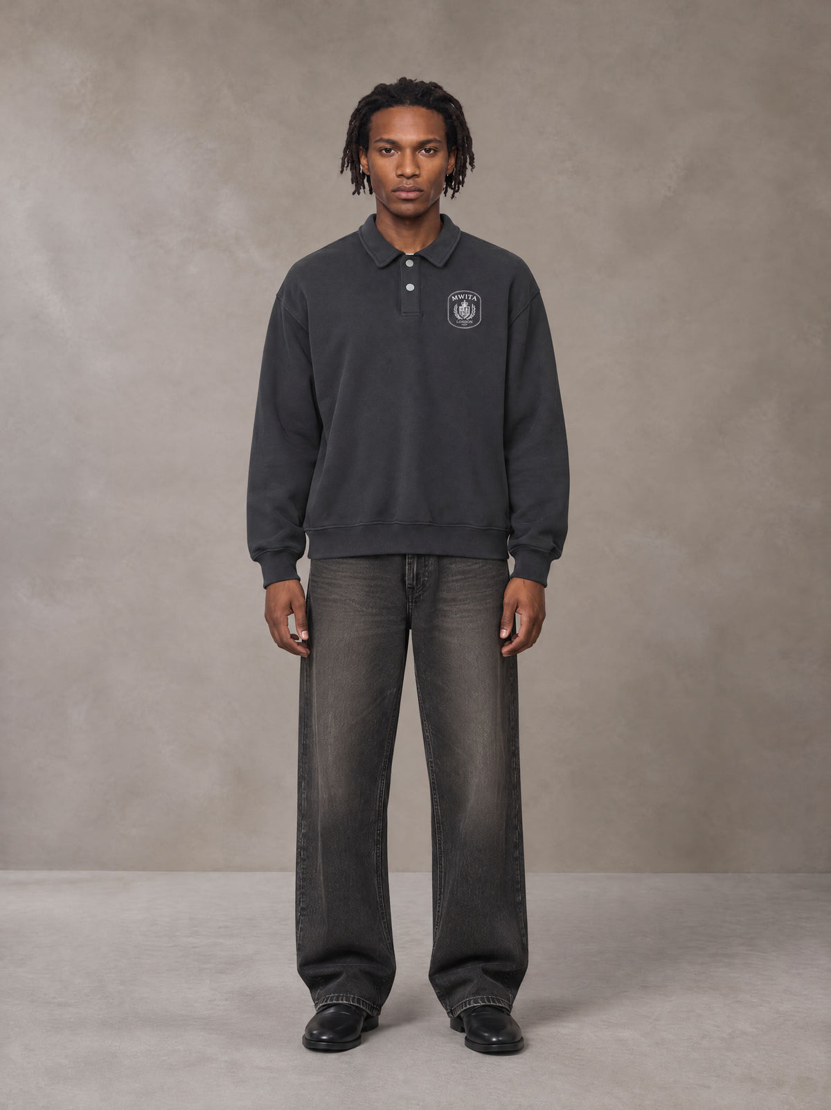 Model wearing the SM Royal Emblem Sweatshirt in Deep Charcoal, front view.