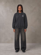 Model wearing the SM Royal Emblem Sweatshirt in Deep Charcoal, front view.
