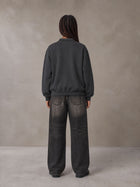 Model wearing the SM Royal Emblem Sweatshirt in Deep Charcoal, rear view.