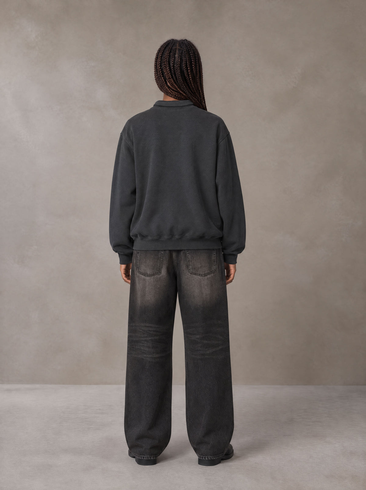 Model wearing the SM Royal Emblem Sweatshirt in Deep Charcoal, rear view.