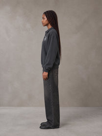 Model wearing the SM Royal Emblem Sweatshirt in Deep Charcoal, side profile.