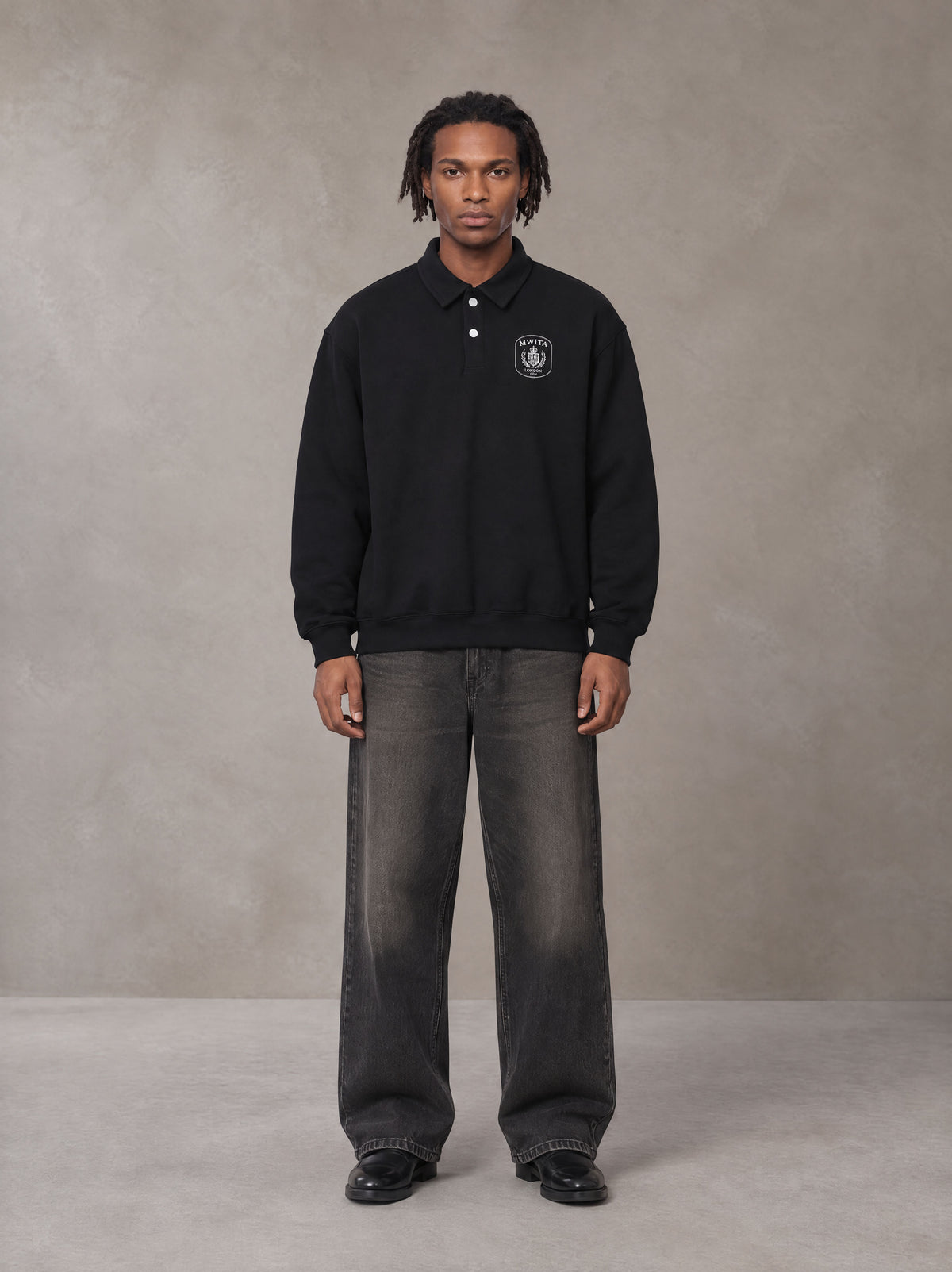 Model wearing the SM Royal Emblem Sweatshirt in Midnight Black, front view.