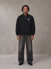 Model wearing the SM Royal Emblem Sweatshirt in Midnight Black, front view.