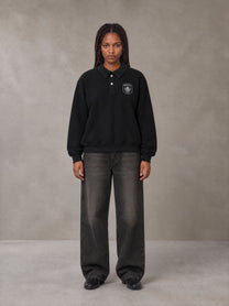 Model wearing the SM Royal Emblem Sweatshirt in Midnight Black, front view.