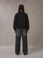 Model wearing the SM Royal Emblem Sweatshirt in Midnight Black, rear view.