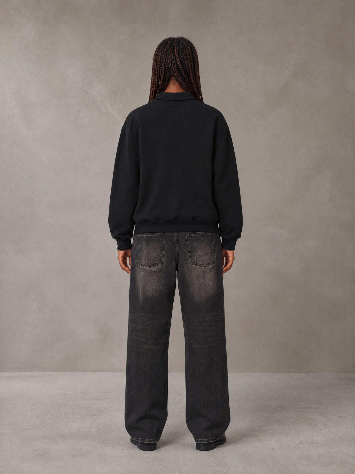 Model wearing the SM Royal Emblem Sweatshirt in Midnight Black, rear view.