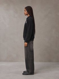 Model wearing the SM Royal Emblem Sweatshirt in Midnight Black, side profile.