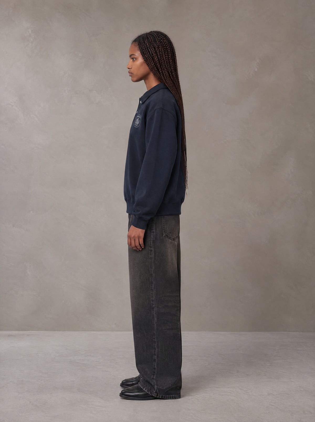 Model wearing the SM Royal Emblem Sweatshirt in Oxford Navy, side profile.