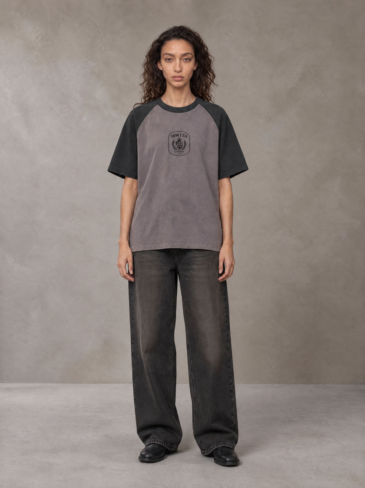 Model wearing the SM Royal Emblem T-shirt in Coffee Grey, front view.