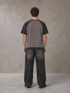 Model wearing the SM Royal Emblem T-shirt in Coffee Grey, rear view.