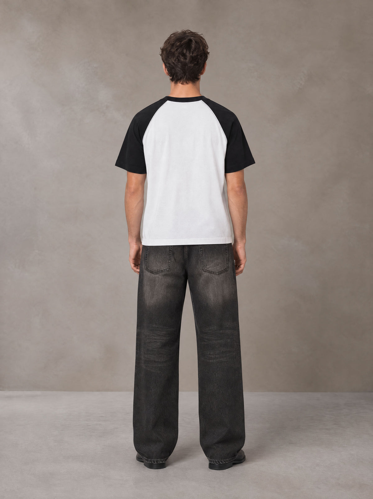 Model wearing the SM Royal Emblem T-shirt in Lucent White, rear view.