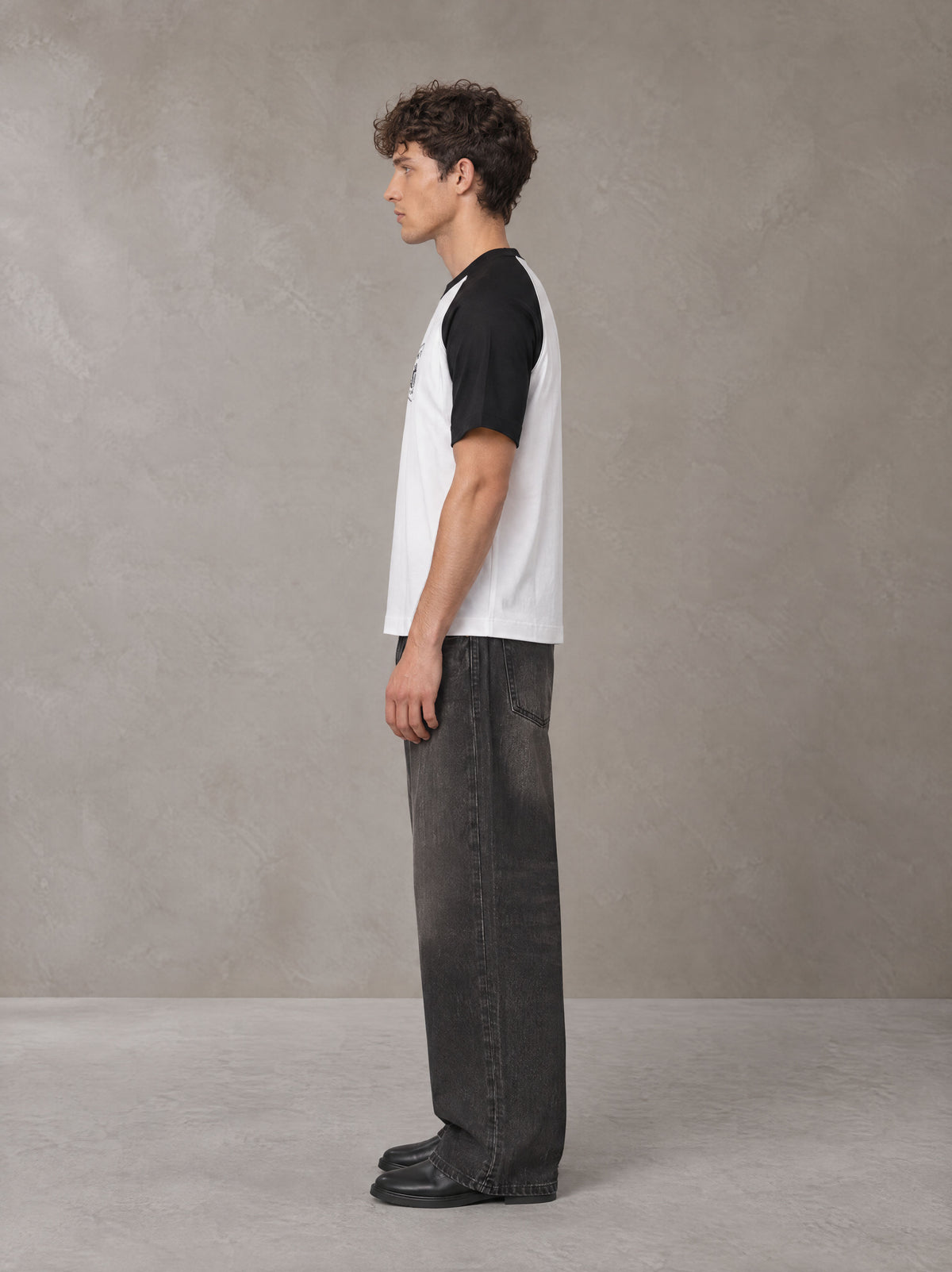 Model wearing the SM Royal Emblem T-shirt in Lucent White, side profile.