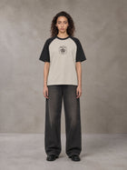 Model wearing the SM Royal Emblem T-shirt in Oatmeal Cookie, front view.