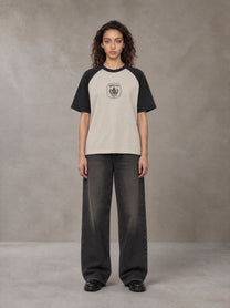 Model wearing the SM Royal Emblem T-shirt in Oatmeal Cookie, front view.