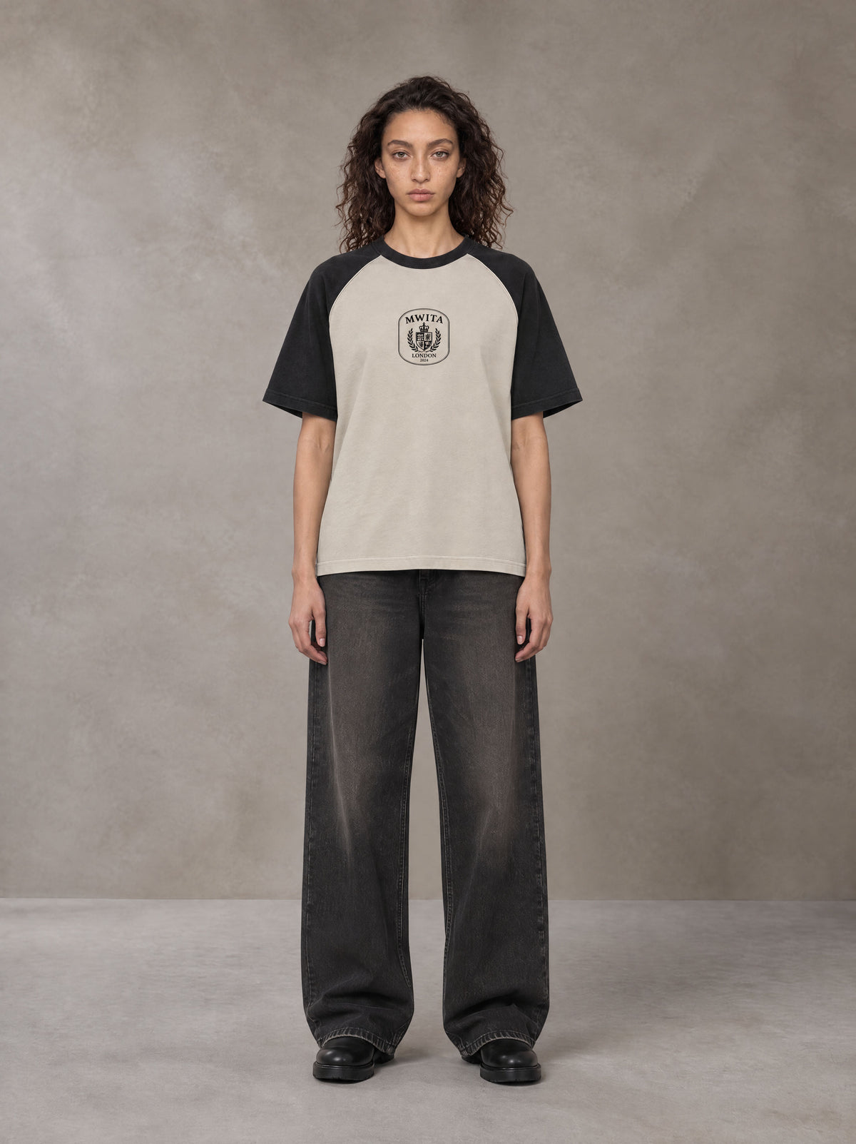 Model wearing the SM Royal Emblem T-shirt in Oatmeal Cookie, front view.