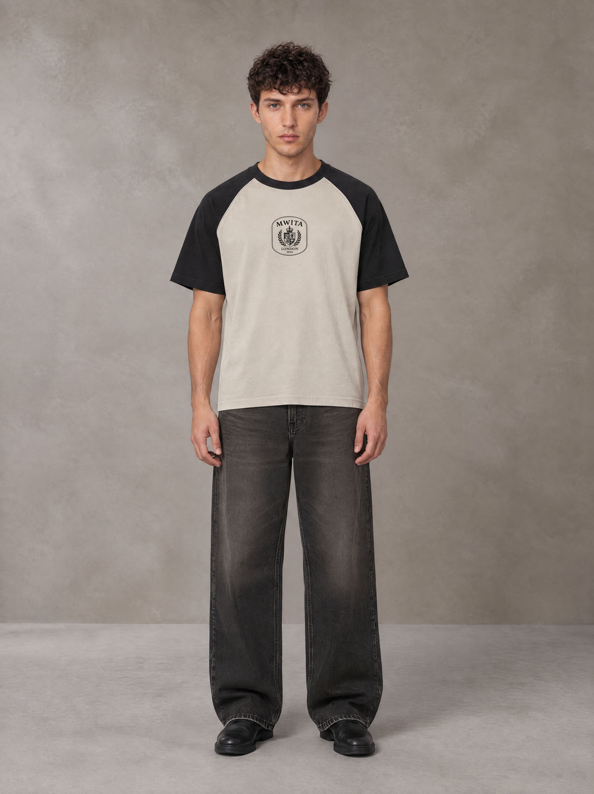 Model wearing the SM Royal Emblem T-shirt in Oatmeal Cookie, front view.