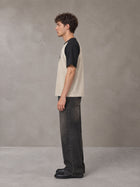 Model wearing the SM Royal Emblem T-shirt in Oatmeal Cookie, side profile.