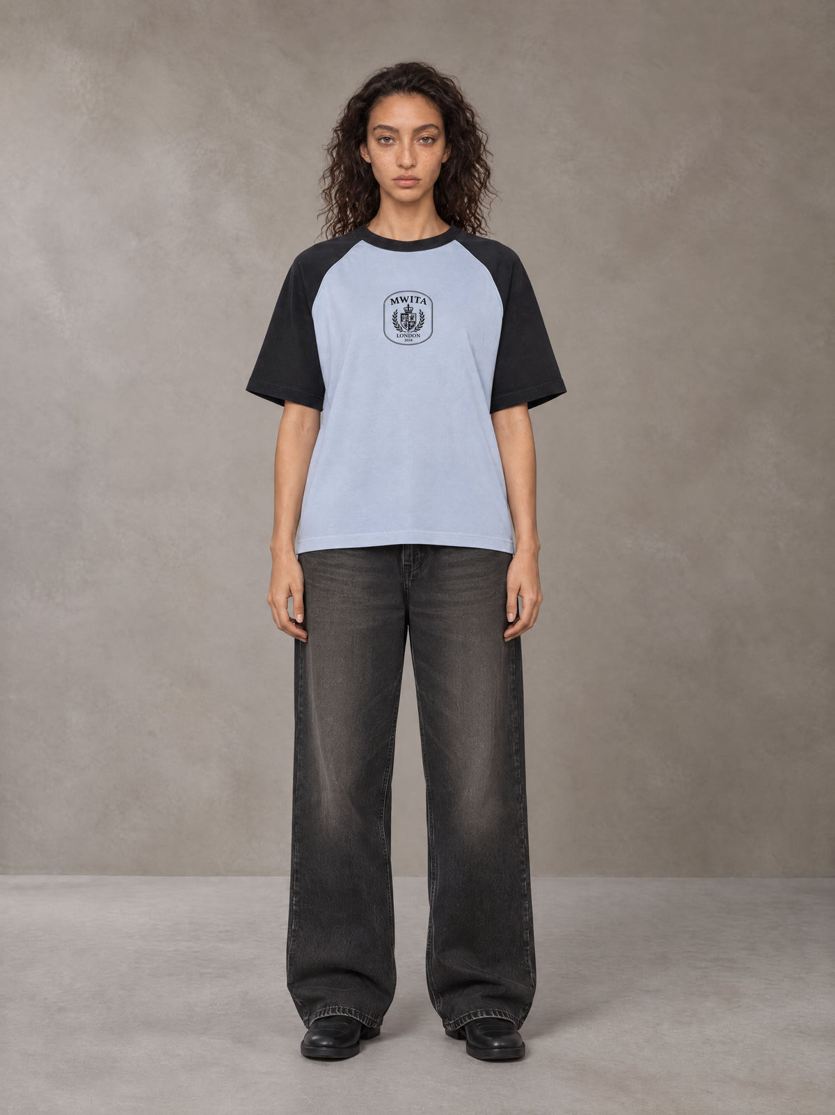 Model wearing the SM Royal Emblem T-shirt in Powder Blue, front view.