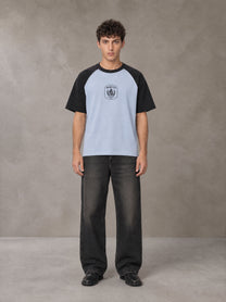 Model wearing the SM Royal Emblem T-shirt in Powder Blue, front view.