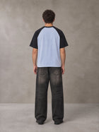 Model wearing the SM Royal Emblem T-shirt in Powder Blue, rear view.