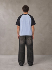 Model wearing the SM Royal Emblem T-shirt in Powder Blue, rear view.