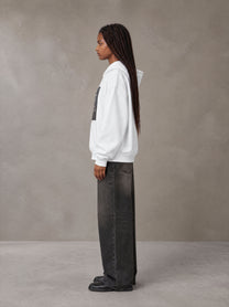 Model wearing the SM Celestial Charge Hoodie in Lucent White, side profile.