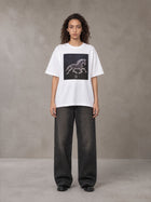 Model wearing the SM Celestial Charge T-shirt in Lucent White, front view.