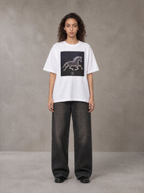 Model wearing the SM Celestial Charge T-shirt in Lucent White, front view.