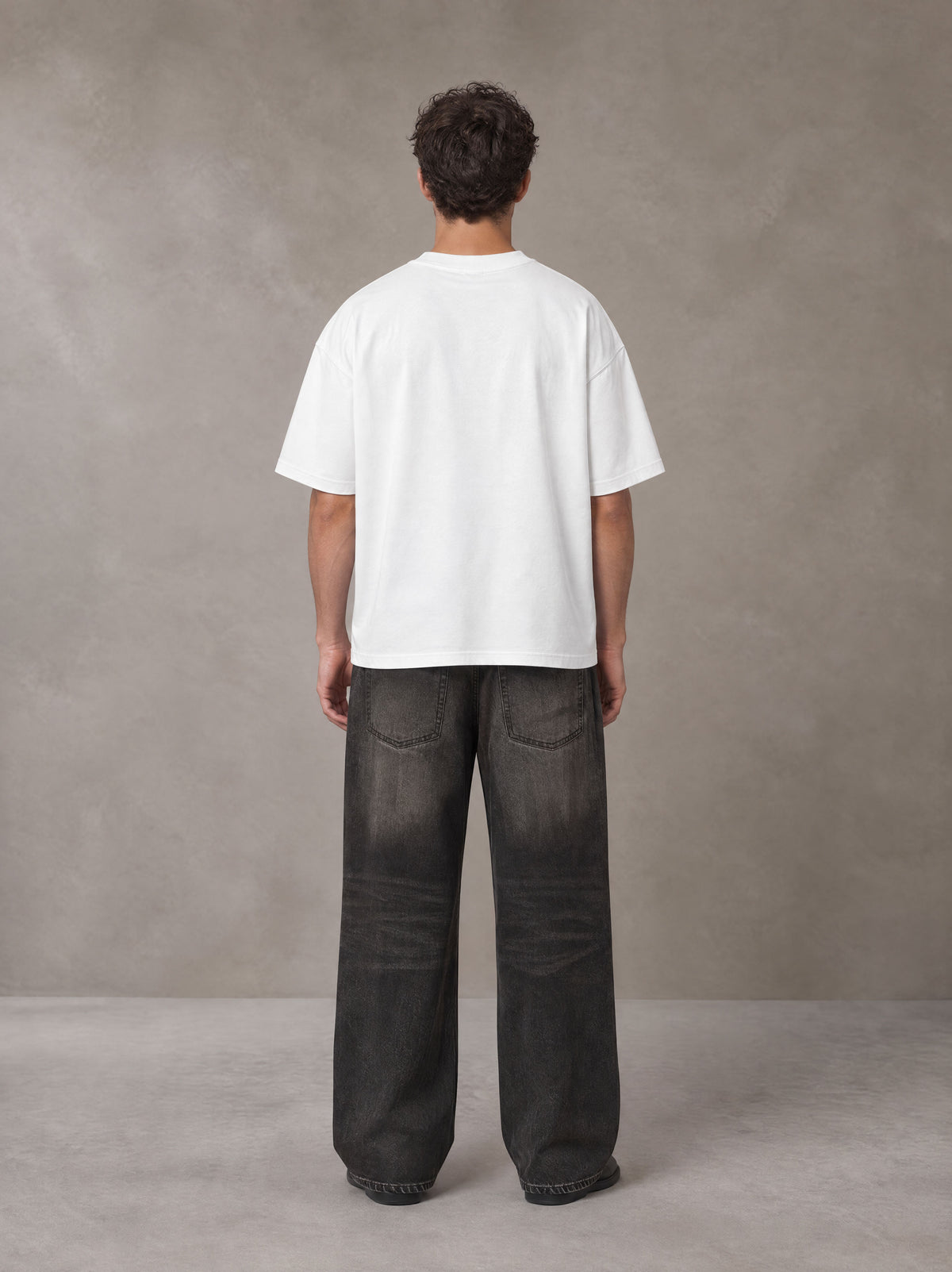 Model wearing the SM Celestial Charge T-shirt in Lucent White, rear view.
