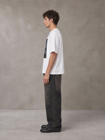 Model wearing the SM Celestial Charge T-shirt in Lucent White, side profile.