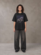 Model wearing the SM Celestial Charge T-shirt in Midnight Black, front view.