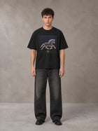 Model wearing the SM Celestial Charge T-shirt in Midnight Black, front view.
