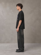 Model wearing the SM Celestial Charge T-shirt in Midnight Black, side profile.