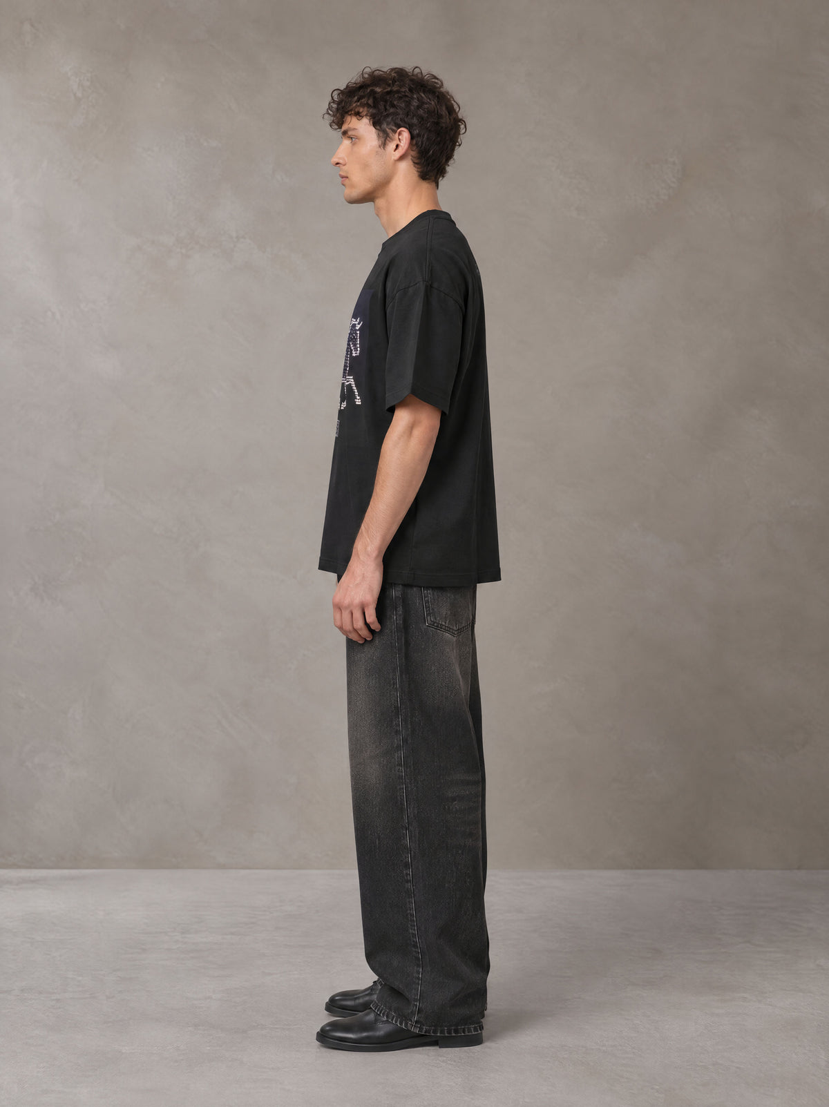 Model wearing the SM Celestial Charge T-shirt in Midnight Black, side profile.